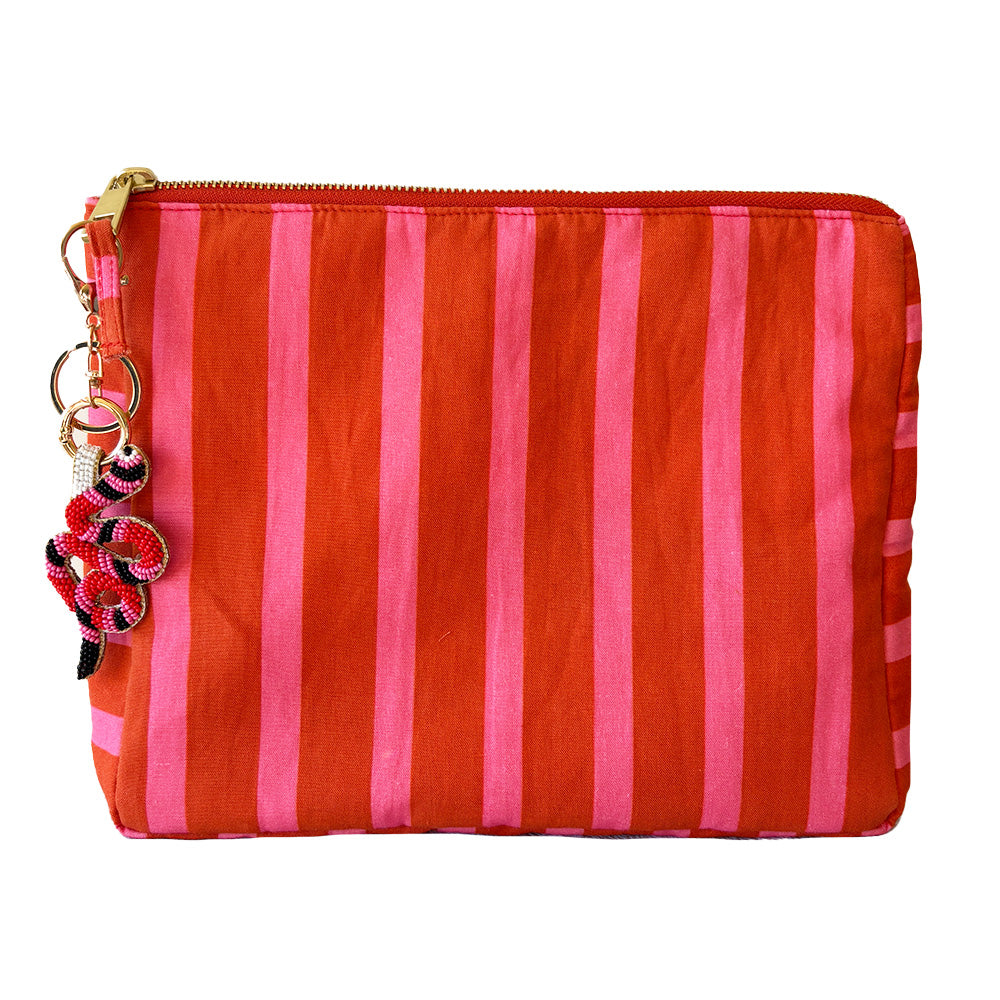 Striped red and pink cosmetic pouch with snake beaded keychain on a white background