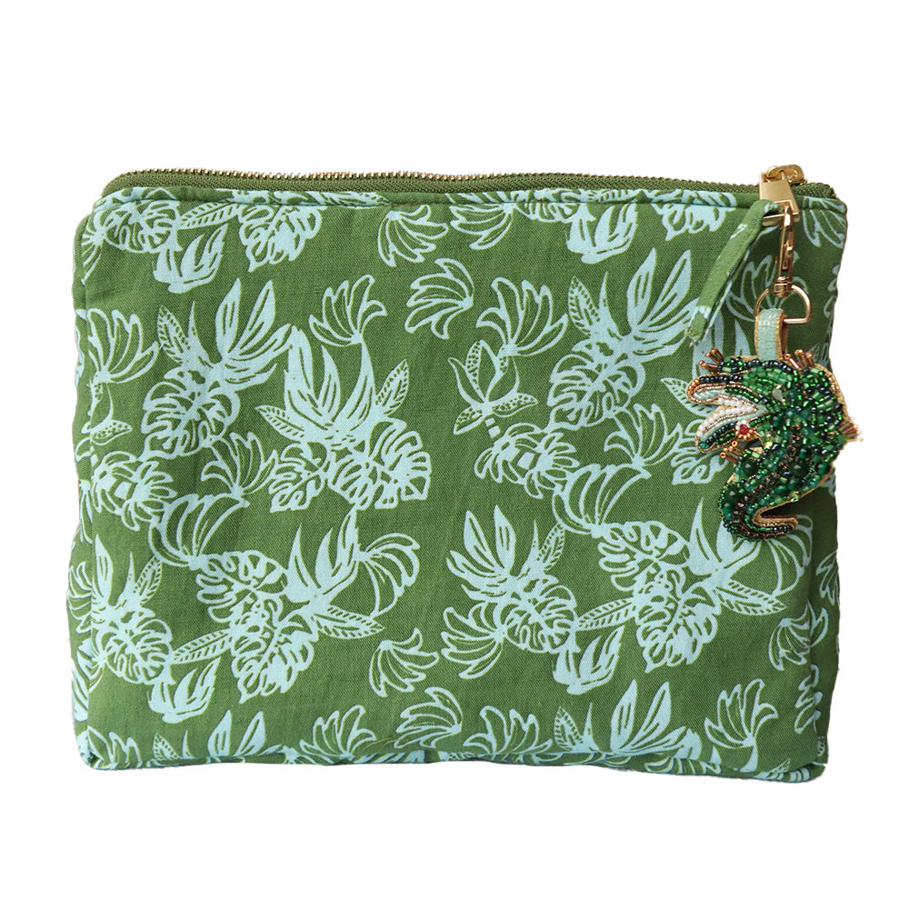 Green cosmetic bag  with blue monstera pattern and decorative and crocodile charm on a white background