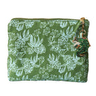 Green cosmetic bag  with blue monstera pattern and decorative and crocodile charm on a white background