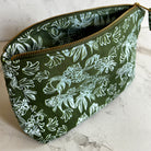 Green pouch with blue floral pattern on a marble surface
