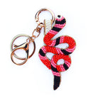 Snake-shaped beaded keychain with pink and black pattern on a white background